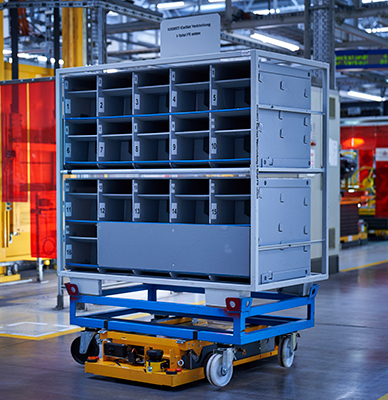 自主移动机器人从云接收的订单和运输带滚轮的容器整个工厂，确保汽车制造商的生产线接收部分可靠和及时。（宝马集团提供）