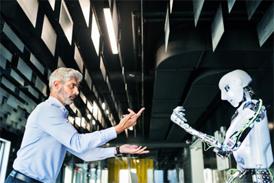 一位行政人员或科学家指挥一个人形机器人的照片