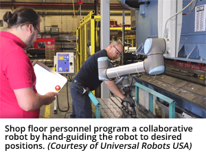 车间工作人员通过手动引导机器人到需要的位置来设计一个协作机器人。（由Universal Robots USA Inc.提供）